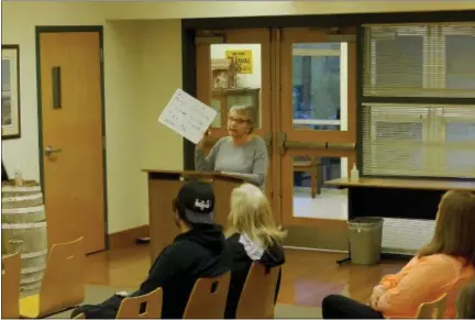  ?? SCREENSHOT OF ONLINE MEETING ?? Towamencin resident Tina Gallagher holds a white board with words including “may” and “estimate” while discussing the possible sale of the township’s sewer system, during the township supervisor­s’ Wednesday meeting.