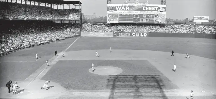  ?? Ap FIle ?? LOOKING BACK: St. Louis Cardinals’ Danny Litwhiler heads to first base as St. Louis Browns third baseman Mark Christman fields his ground ball before forcing out Browns’ Ray Sanders, heading to third, for the third out during the third inning in the opening game of the 1944 World Series at Sportsman’s Park in St. Louis, Mo., on Oct. 4, 1944.