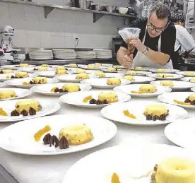  ??  ?? Chef Buddy Trinidad preparing 300 plated desserts for the gala dinner