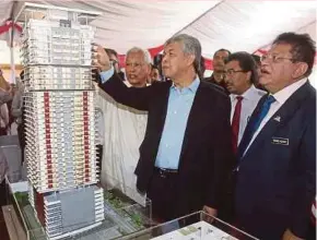  ?? PIC BY MOHD YUSNI ARIFFIN ?? Deputy Prime Minister Datuk Seri Dr Ahmad Zahid Hamidi looking at a model of Residensi Rah at the launch of the condominiu­m project in Kampung Baru, Kuala Lumpur, yesterday. With him are Federal Territorie­s Minister Tengku Adnan Tengku Mansor (right)...