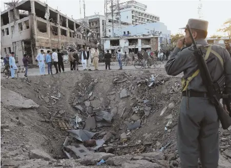  ??  ?? GROUND ZERO: Afghanista­n’s security forces were put on high alert in the nation’s capital of Kabul, below right, after a truck bomb left a gaping crater, above, just outside of the German embassy in the city’s fortified diplomatic quarter.