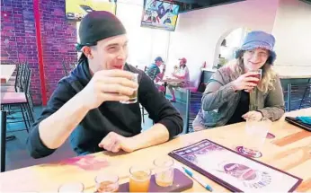  ?? STEPHEN M. DOWELL/ORLANDO SENTINEL ?? Ryan Buchanan, left, and Robyn Williams enjoy beers Thursday at Motorworks Brewing in downtown Orlando.