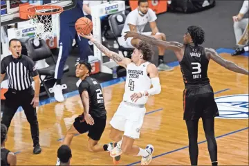  ?? AP - Gerry Broome ?? Georgia Tech guard Jordan Usher goes up for a shot as Miami’s Isaiah Wong (2) and Nysier Brooks defend during the second half of Thursday’s ACC tournament quarterfin­al.