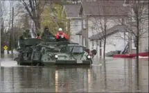  ?? ADRIAN WYLD, THE CANADIAN PRESS ?? A military vehicle drives along a flooded street Sunday in Gatineau, Que., where more than 1,000 homes are under evacuation orders.