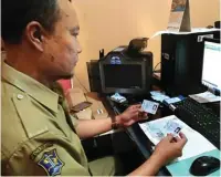  ?? THORIQ KARIM/JAWA POS ?? TELITI: Jarot, petugas Kecamatan Sawahan, memeriksa e-KTP warga.