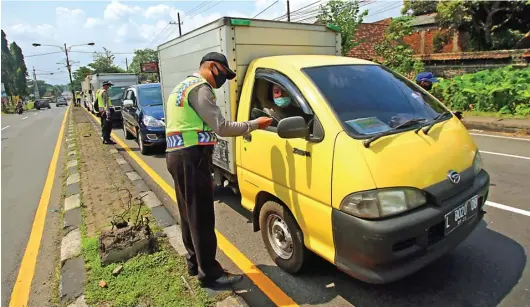  ?? DARMONO/JAWA POS RADAR MALANG ?? TERAPKAN PEMBATASAN: Polisi memeriksa dokumen pengendara di checkpoint Lawang, Kabupaten Malang. Kemarin merupakan hari pertama PSBB di Malang Raya.