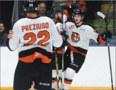  ?? NEWS PHOTO RYAN MCCRACKEN ?? Medicine Hat Tigers (from left) Tyler Preziuso, Ryan Jevne and Ryan Chyzowski celebrate after scoring a goal in a Western Hockey League game against the Kootenay Ice on Jan. 17, 2018 at the Canalta Centre. The three teammates are entering their third line together as a forward line.