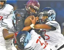  ?? STAFF PHOTO BY ROBIN RUDD ?? Brainerd’s Donivon Thomas, left, Allen Ware (32) and Kedavion Chapman, right, tackle Howard’s Deorean Elder on Friday night at Howard.