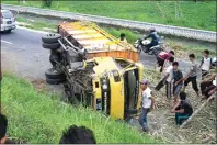  ?? JAWA POS RADAR MOJOKERTO ?? TUTUPI JALAN: Truk yang mengangkut bibit tebu terguling di jalan raya Desa Jatigedong, Kecamatan Ploso, Jombang, kemarin.