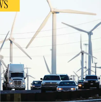  ?? DAVID MCNEW / GETTY IMAGES ?? Trucks and cars pass windmills along the 10 Freeway in California, an area increasing­ly hit by drought and wildfires.