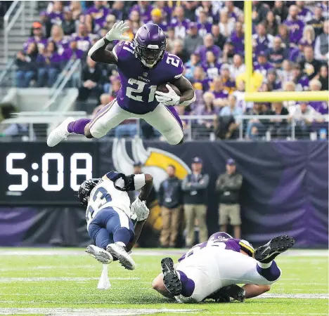  ?? ADAM BETTCHER/GETTY IMAGES ?? Jerick McKinnon of the Minnesota Vikings leaps over defender Nickell Robey-Coleman of the Los Angeles Rams in the first quarter at U.S. Bank Stadium in Minneapoli­s, Minn., on Sunday. “We got humbled today by a very good team,” said Rams coach Sean McVay.