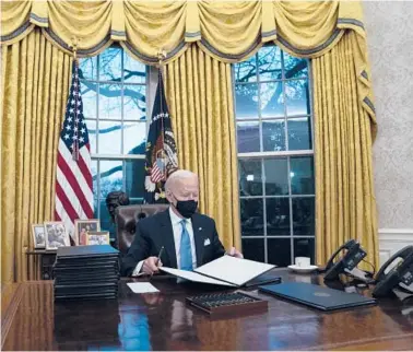  ?? EVAN VUCCI/AP ?? President Joe Biden signs a series of executive orders on Inaugurati­on Day at the White House in Washington.