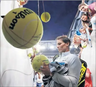  ??  ?? MISIÓN CUMPLIDA. Nadal firma autógrafos en el túnel de vestuarios.