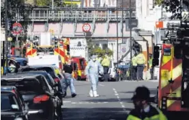  ?? AP ?? Autoridade­s forenses caminan cerca del tren donde estalló una bomba casera, en la estación Parsons Green del metro de Londres.