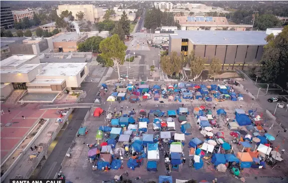  ?? JAE C. HONG/ASSOCIATED PRESS ?? A large homeless encampment fills up the Plaza of the Flags elevated park at the Santa Ana Civic Center complex on Oct. 11, 2017, in Santa Ana, Calif. California declared a statewide emergency due to a hepatitis A outbreak linked to homeless...