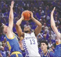  ?? The Associated Press ?? E-RUPP-TION: Kentucky’s Isaiah Briscoe (13) shoots while defended by, from left, UCLA’s Bryce Alford, Lonzo Ball, and Thomas Welsh during first-half action Saturday at Rupp Arena in Lexington, Ky. Eleventh-ranked UCLA stunned the No. 1 Wildcats 97-92,...