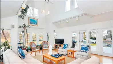  ??  ?? The great room-style family room at 18 Grimes Road is a bright, inviting space, thanks to the high ceilings and abundance of glass — oversized windows, French doors and skylights welcome in an abundance of natural light and frame the water views.