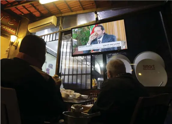  ?? AFP ?? Residents watch an interview with the country’s former prime minister Saad Hariri, in which he vowed to return soon, at a coffee shop in Beirut on Sunday