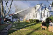  ??  ?? Firefighte­rs battle a house fire Thursday in North Andover, Mass., part of a series of gas explosions and fires triggered by a problem with a gas line.