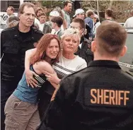  ?? ED ANDRIESKI/AP ?? A mother and daughter reunite after a shooting on April, 20, 1999, at Columbine High School in Littleton, Colo. Two students killed 12 others and a teacher
before dying by suicide.