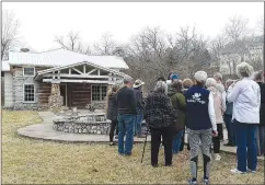  ?? Submitted photo ?? Dale Phillips (in blue hat at center) tells a March 2022 tour group about the history of the oldest standing structure in Bella Vista.