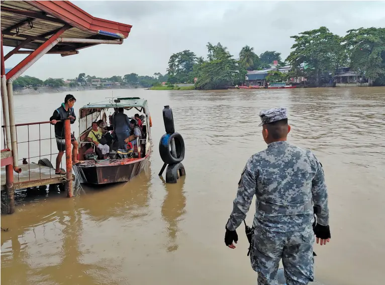  ?? BING GONZALES between Bangkaan and SIR Matina rainy ?? COAST Guard Station Davao personnel closely monitor the Davao Thursday, Jan. 18, 2024.
River for possible changes as several passenger boats cross on a