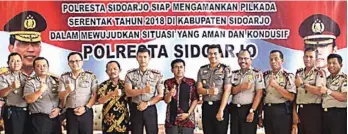  ?? EDI SUDRAJAT/JAWA POS ?? KONSOLIDAS­I: Kombespol Himawan Bayu Aji (lima dari kiri) foto bersama seluruh jajaran, KPU, dan Panwaslu Sidoarjo kemarin. Total terdapat 1.050 personel pengamanan. Jumlah tersebut belum termasuk petugas linmas yang ikut siaga di TPS.