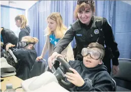  ?? PIERRE OBENDRAUF ?? Montreal police Const. Liliana Bellucci helps Grade 6 student Massimo Fortino manipulate a simulated drunk-driving scenario at the Sarto-Desnoyers Community Centre in Dorval.