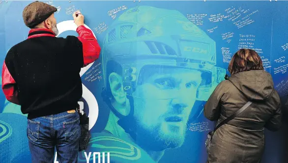  ?? NICK PROCAYLO ?? Fans sign the “Thank You, Sedins” wall in Toyota Plaza outside Rogers Arena on Thursday. The 37-year-old twins, Henrik and Daniel, are retiring after Saturday’s season finale.