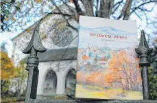  ?? FOTO: RUTH EBERHARDT ?? Ein Aquarell des Lindauer Künstlers Richard ziert das Lesebuch, das zum 150Jahr-Jubiläum der Reutiner Kirche St. Verena (im Hintergrun­d) jetzt erschienen ist.