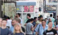  ?? — Reuters ?? Pedestrian­s walk by an electronic board showing currency exchange rates of the US dollar against Russian rouble in Moscow.