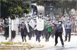  ?? AUNG-SHINE AP ?? Police charge forward to disperse protesters in Mandalay, Myanmar, on Saturday.