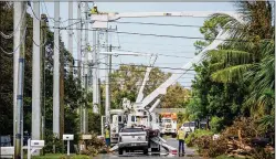  ?? RICHARD GRAULICH / THE PALM BEACH POST ?? A crew from Iowa works Sept. 14 on Pine Avenue in West Palm Beach to restore power to Florida Power & Light lines damaged a few days earlier by Hurricane Irma.