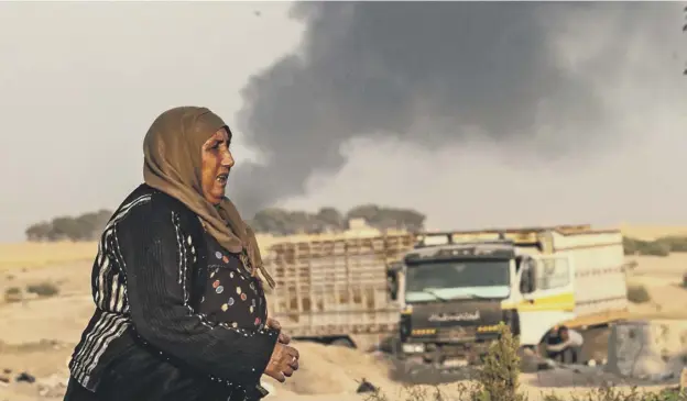  ?? PICTURE: GETTY IMAGES ?? 0 A woman stands in front of billowing smoke following a bombardmen­t in the Syrian town of Ras al-ain in Hasakeh province along the Turkish border