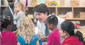  ?? TIJANA MARTIN THE CANADIAN PRESS ?? Prime Minster Justin Trudeau chats with children in child care at Don Christian Recreation Centre in Surrey, B.C., on Thursday. Trudeau blamed Conservati­ve premiers for “slow-walking” child-care rollout and taking their cues from federal Tory leader Pierre Poilievre.