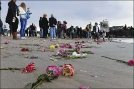  ?? DEAN LEWINS / AAP IMAGE
Associated Press ?? Family and friends gather Wednesday on a beach in a suburb of Sydney, Australia, after a candleligh­t vigil where they threw pink flowers into the ocean for Justine Damond, who was killed by a Minneapoli­s police officer after making a 911 call.