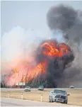  ?? BLOOMBERG ?? A wildfire burns behind abandoned vehicles in Alberta, Canada, on Saturday.