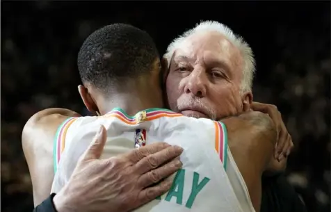  ?? Associated Press ?? Spurs coach Gregg Popovich embraces Dejounte Murray after Friday’s win against the Jazz in San Antonio.