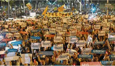  ?? — AFP ?? Making a stand: People holding placards reading ‘Help Catalonia’ and ‘Freedom’ during a demonstrat­ion in Barcelona against the arrest of two Catalan separatist leaders.