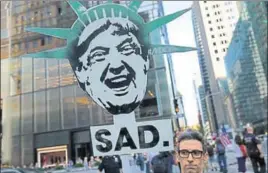  ??  ?? A protester in New York at a demonstrat­ion during Trump’s birthday on Wednesday.