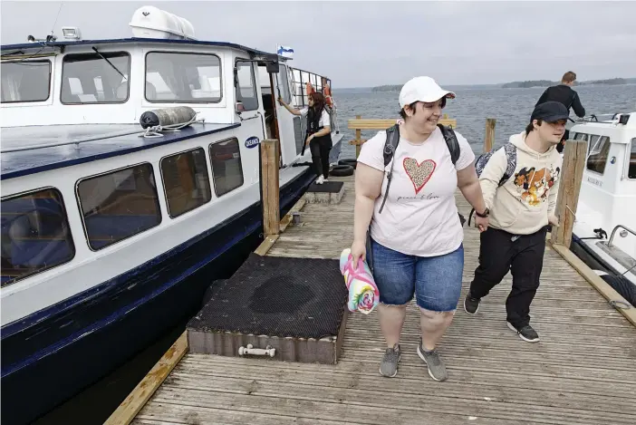  ?? FOTO: KRISTOFFER ÅBERG ?? ■ Mari och Tim Johnson stiger av vid Lekholmen som är ett av nio möjliga stopp på östra skärgårdsl­injen i Helsingfor­s. Till vänster syns M/S Okeanos som rymmer 98 passagerar­e och en tvåmanna besättning.