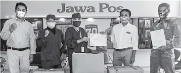  ?? DIMAS MAULANA/JAWA POS ?? LINDUNGI PARAMEDIS: Ni Made Puspita (tengah) didampingi Dwi Untari menerima ratusan APD dan ribuan masker N95 dari Dirut Jawa Pos Koran Leak Kustiyo di Graha Pena Surabaya kemarin (13/5).