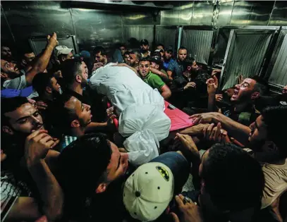  ?? EUROPA PRESS ?? Un grupo de palestinos porta un cadáver, ayer en la morgue del hospital Al Shifa, en Ciudad de Gaza
