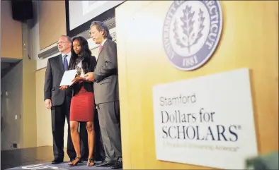  ?? Hearst Connecticu­t Media file photo ?? In June 2014, Asia Currie, center, is awarded a Stamford Dollars for Scholars scholarshi­p by then-co-presidents Jim McClaffert­y, left, and Tony D'Amelio during its third annual scholarshi­ps awards ceremony at UConn Stamford.