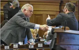  ?? ALYSSA POINTER / ALYSSA.POINTER@AJC.COM ?? State Rep. Micah Gravley (left) receives a congratula­tory shake from a constituen­t after HB 324 was passed by the House on March 5. The bill allows medical marijuana oil to be sold to registered patients, giving them a legal way to obtain a drug that they’re already allowed to use.