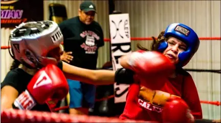  ??  ?? Sarahi Sanchez, 12, (right) attempts to dodge a punch from her opponent during Calexico Boxing Academy’s fundraisin­g event held Friday night in Calexico. VInCent oSUnA Photo