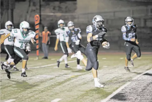  ?? PHOTOS BY LUIS SÁNCHEZ SATURNO/THE NEW MEXICAN ?? Capital’s Luke Padilla scores one of his five touchdowns Friday against Pojoaque. ‘I’m done talking about us being a young team,’ coach Bill Moon said after the 67-14 pounding of the Elks. Several of the Jaguars starters are underclass­men.