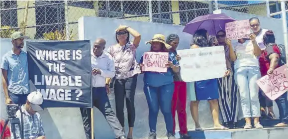  ?? (Photo: Kasey Williams) ?? Placard-bearing teachers protesting outside the Ministry of Education Region Five office in Mandeville last Friday.