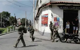  ?? Ricardo Moraes/Reuters ?? Policiais do Bope armados durante operação no complexo do Alemão, zona norte do Rio