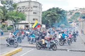  ??  ?? Varios “colectivos” (grupos formados y armados por el chavismo) se desplazan en motos, y disparan al pasar ante marchas opositoras.